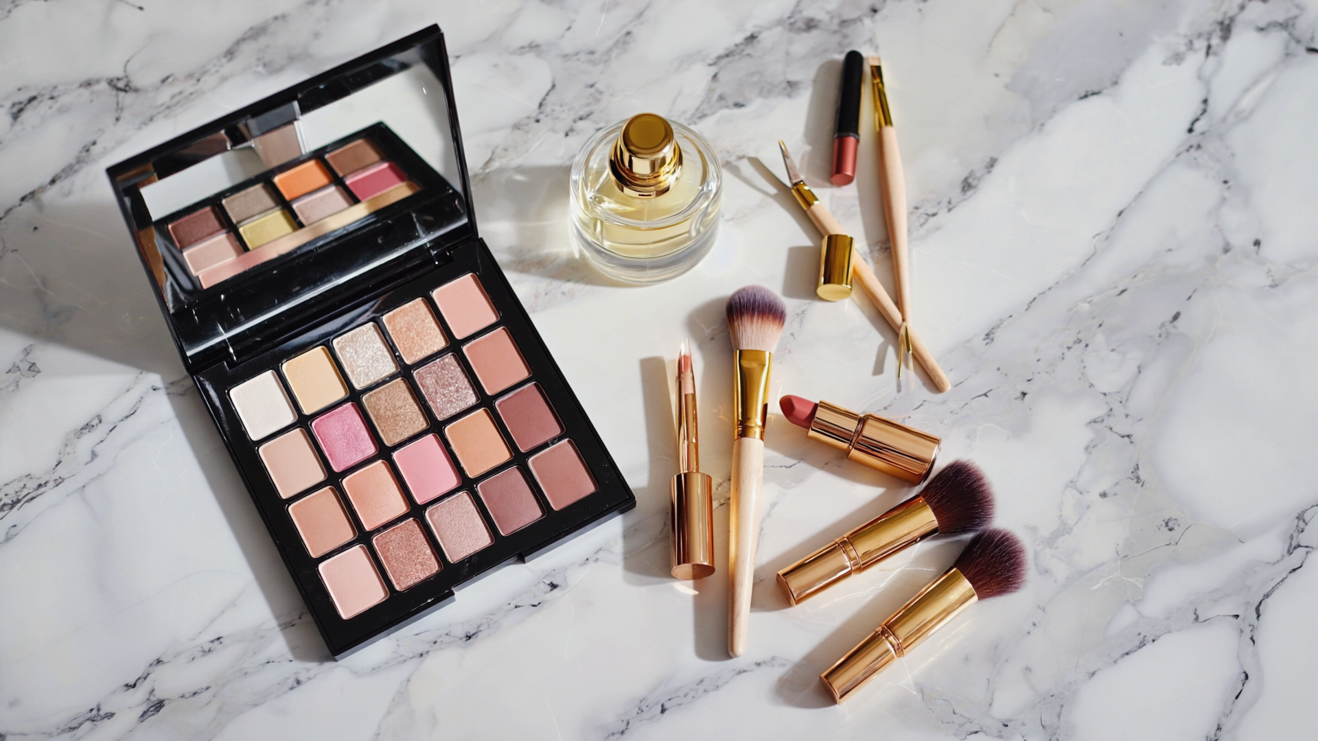 Flat-lay editorialer Kosmetik: Palette, Pinsel, Parfum, Pinzette auf Marmor.
